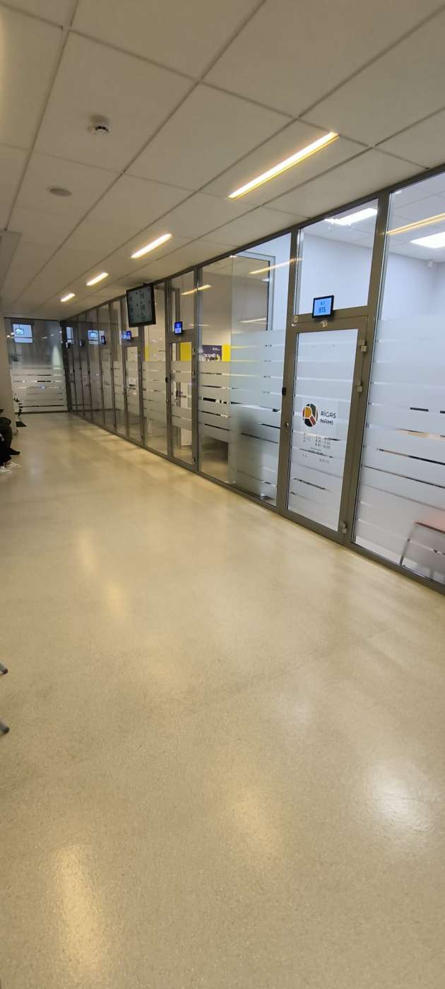 Vairākas stiklotas durvis, virs durvīm tablo ar numuriem