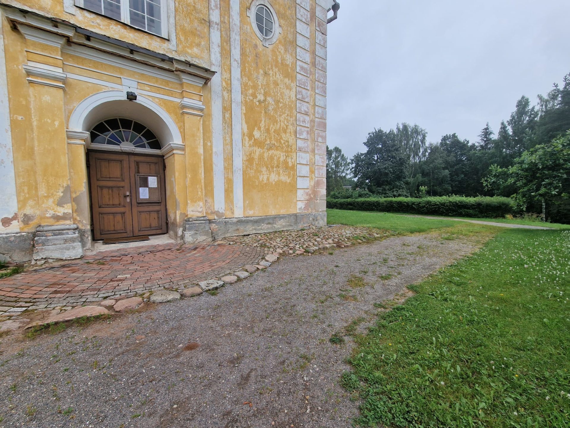 Võnnu chucrh entrance with a little uneven pavement and a step