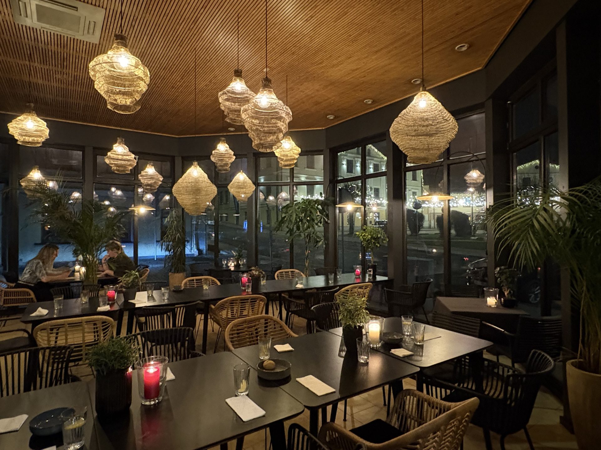 Fotol on kohviku sisevaade mis on õdus, kuid hämarapoolne, rippuvate kohtvalgustitega