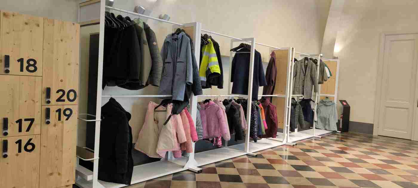 Garderobe pie sienas, kur drēbes var atstāt arī cilvēki ratiņkrēslos