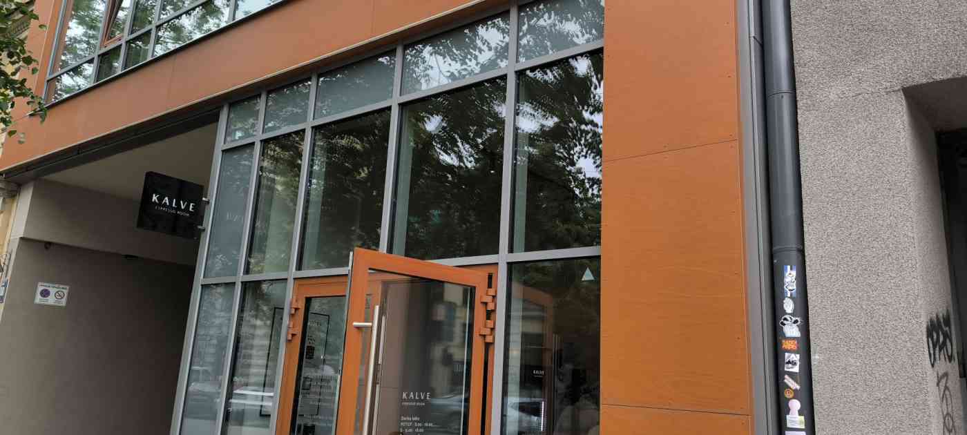 Vairākstāvu stiklota ēka, sānā uzraksts Kalve Espresso Room